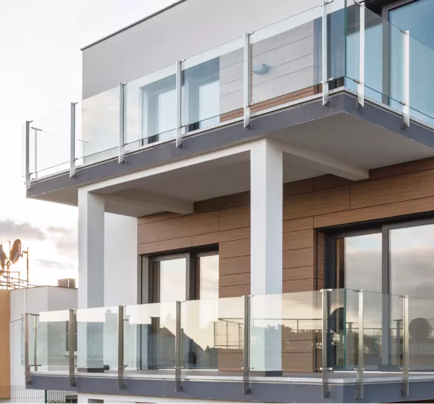 Auf diesem Bild sieht man ein Haus mit zwei Balkonen und Balkongeländern mit Glas.