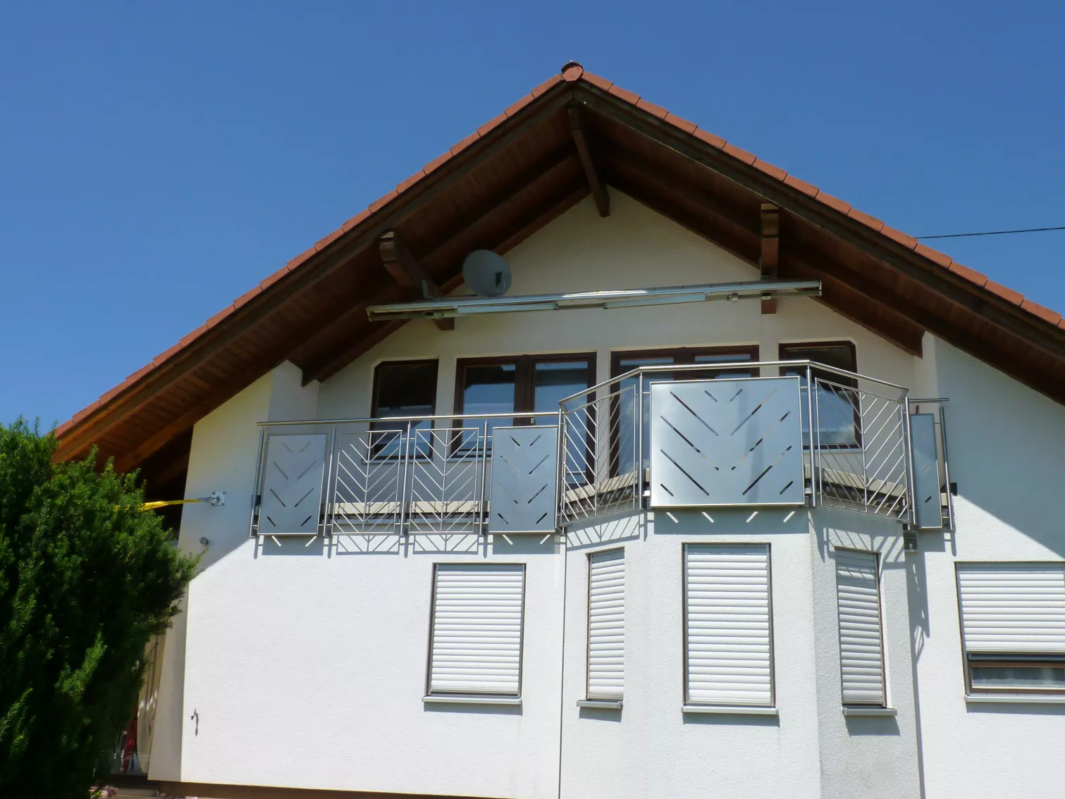 Ein Haus mit einem Balkon, welches ein Balkongeländer aus Edelstahl hat.